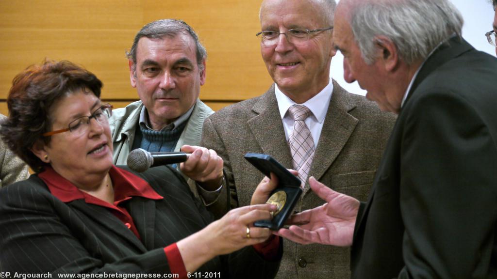 Madame la maire de Pouldreuzic  Marie-Thérèse Gourlaouen  
remet la médaille de la ville à Michel Priziac  président le 
l\'association des écrivains bretons (à droite). Au centre Bernard 
Le Floc\'h  vice président de l\'institut culturel de Bretagne.