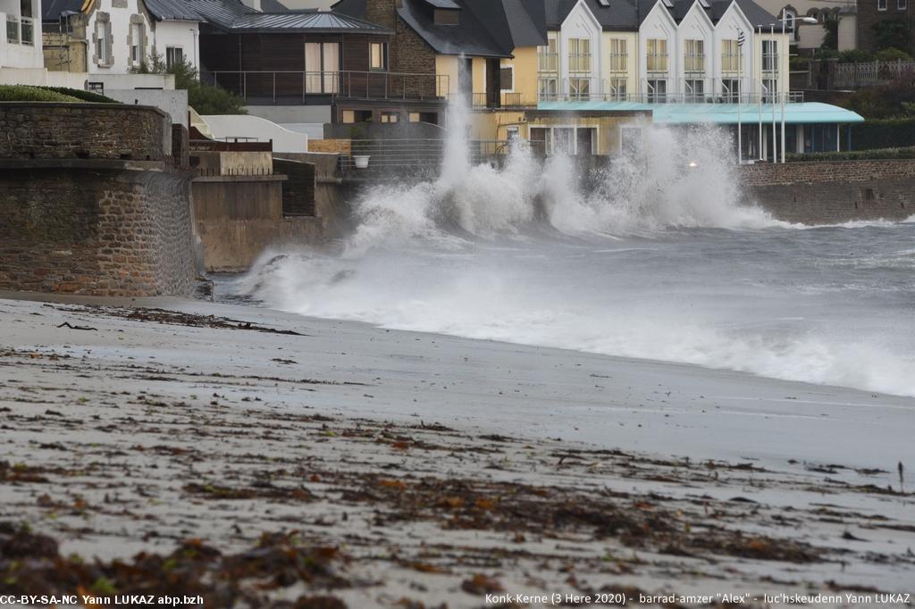 Konk-Kerne, gwener da noz (02 Here 2020). La voiture est masquée par les embruns. Des panneaux disposés à intervalle indiquent un "risque de submersion possible" pour la chaussée.