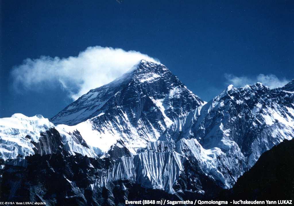 Everest (8848 m) gwelet eus bro-Nepal. L'Everest, comme un diamant, aux trois faces (une népalaise, deux tibétaines), et aux trois noms (Everest/Sagarmatha/Chomolungma). La VN (voie normale, historique de 1953) emprunte le profil-frontière à droite du sommet sur la photo (depuis le Col Sud, 7980 m). Sous le panache, l'on aperçoit l'un des versants tibétains. La face SW, népalaise, bien visible, a éét gravie en 1975 par une expédition britannique (Chris Bonington)